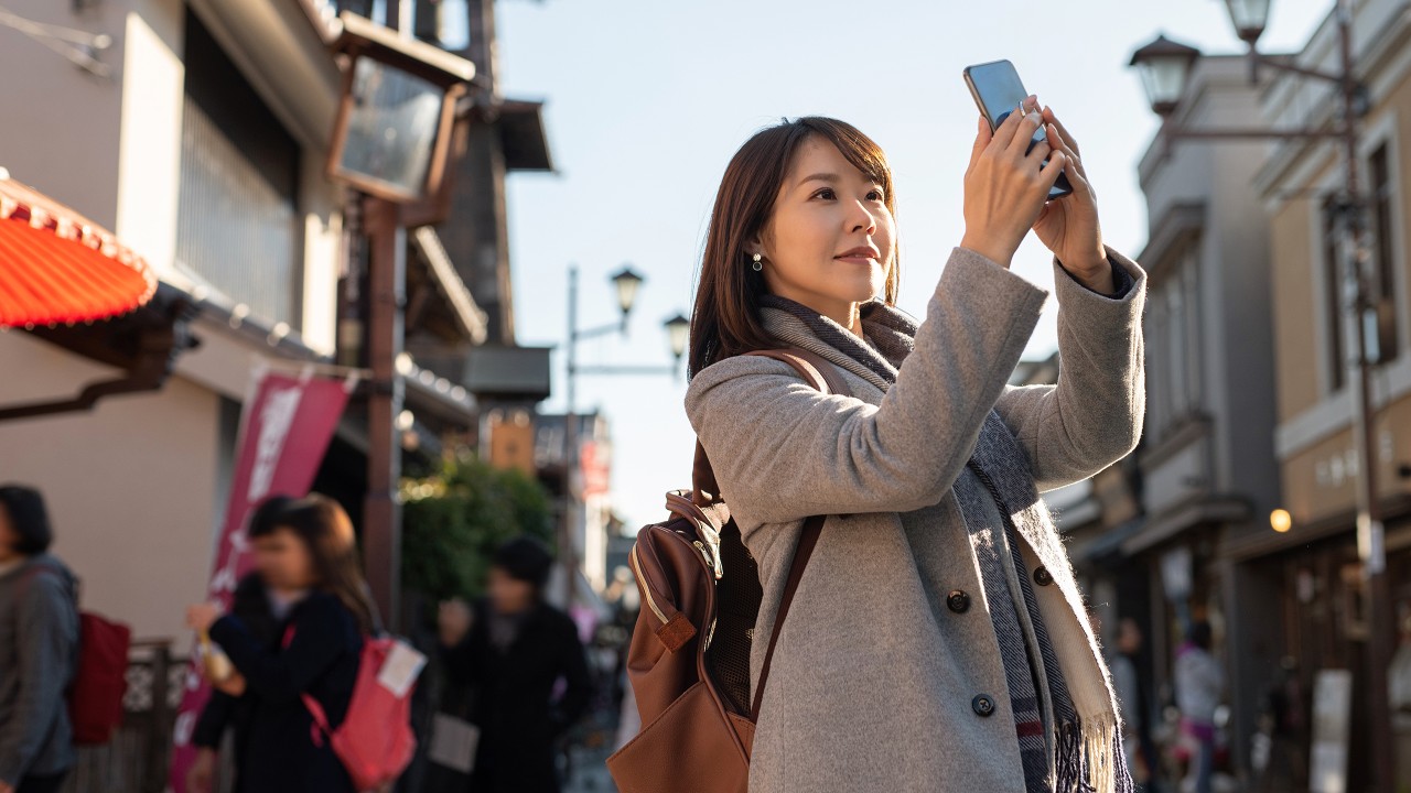 一位女士正在用手机拍照； 图片使用于汇丰"现金套现"分期计划文章。