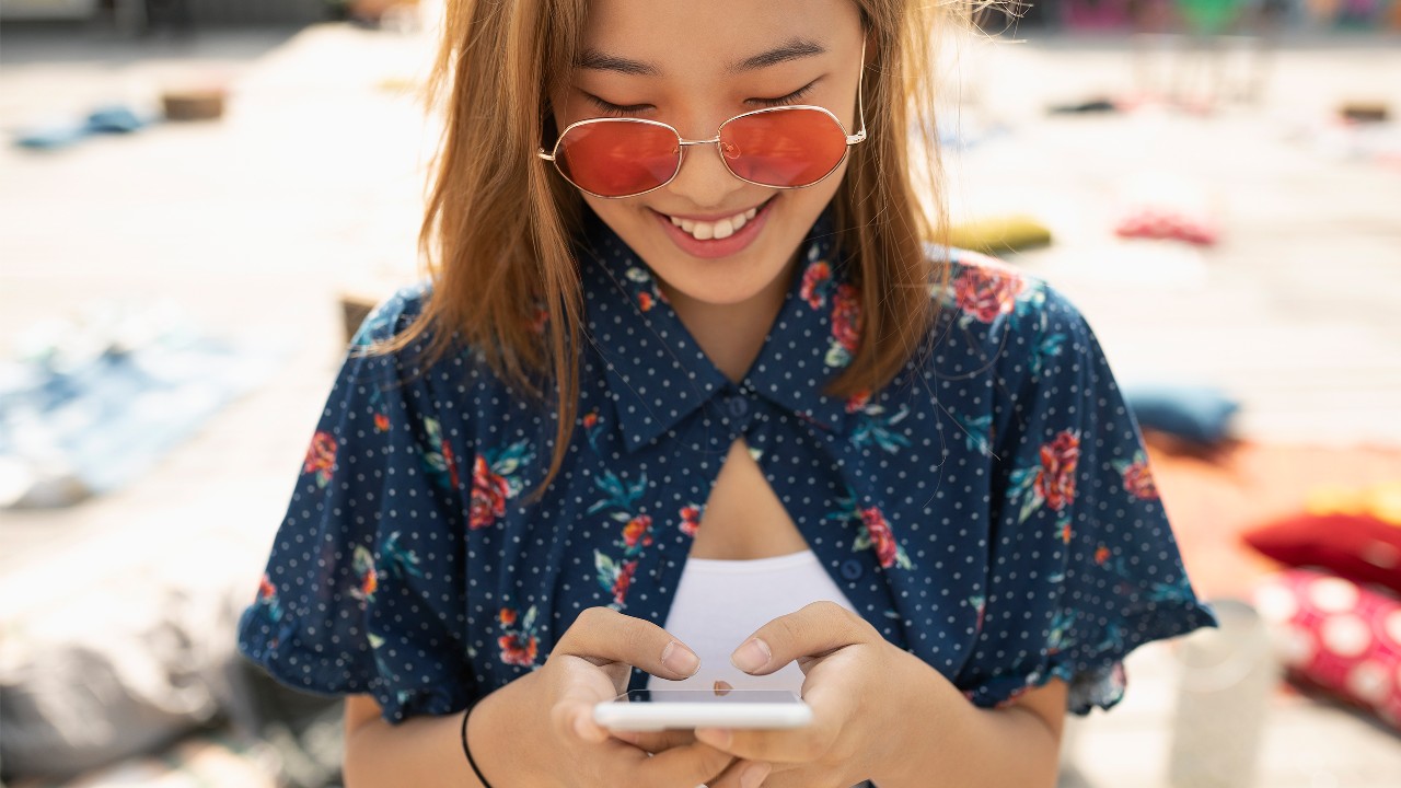 Woman looking at her phone; image used for HSBC Red Hot Rewards.