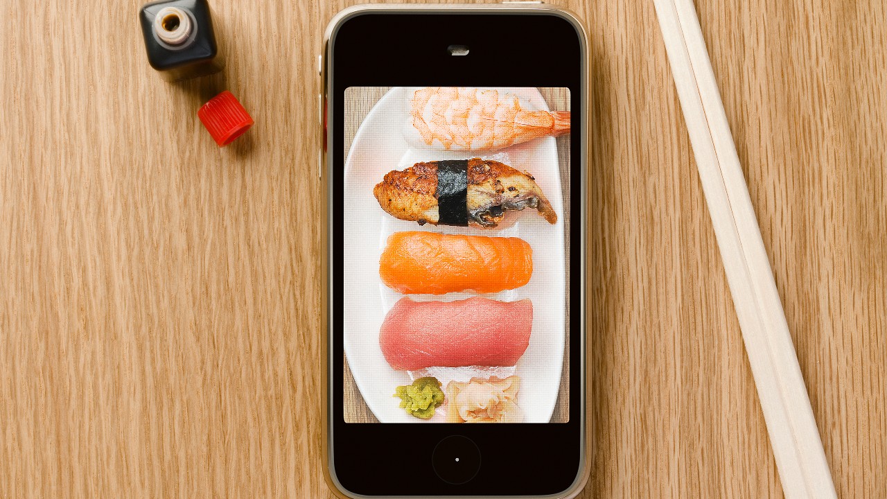 Mobile and chopsticks putting on the table; image used Rack up online spending offers with your HSBC Red Credit Card.