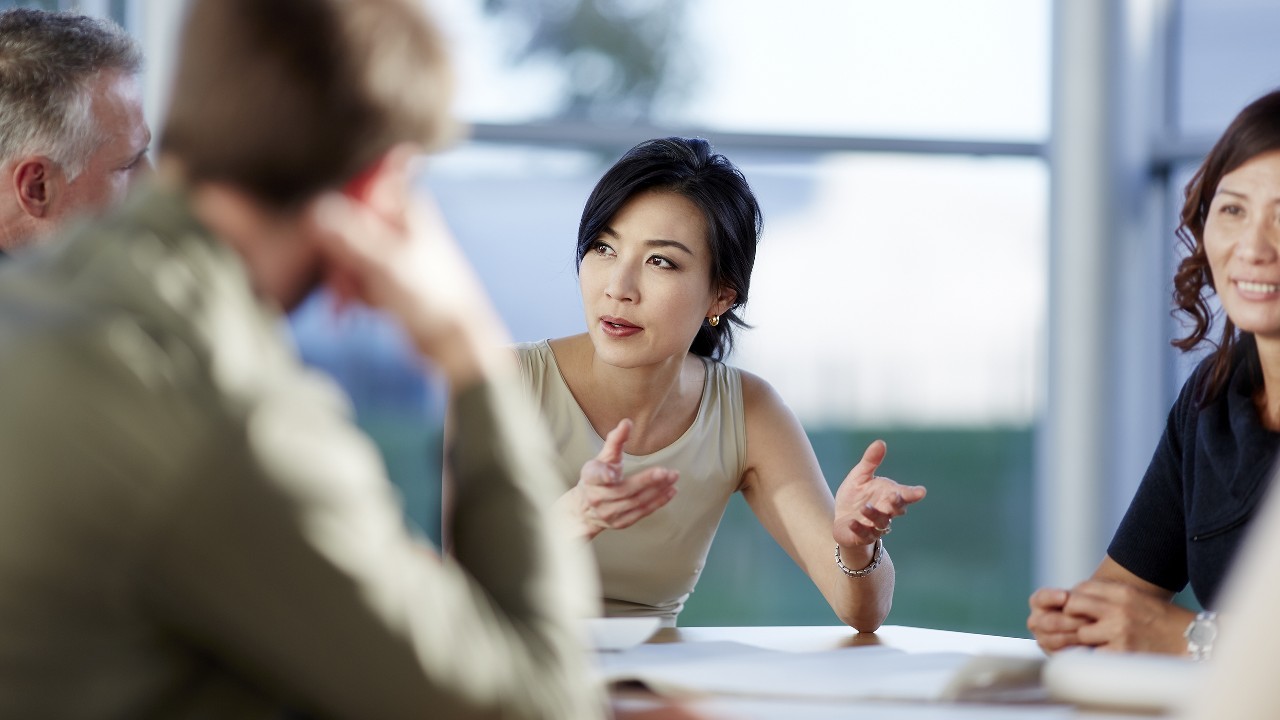 A woman discussing with her teammates in a meeting; image used for commercial banking