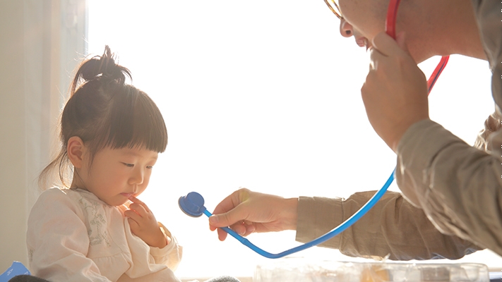 Dad and daughter are playing with a stethoscope;  image used for Outpatient Care page.