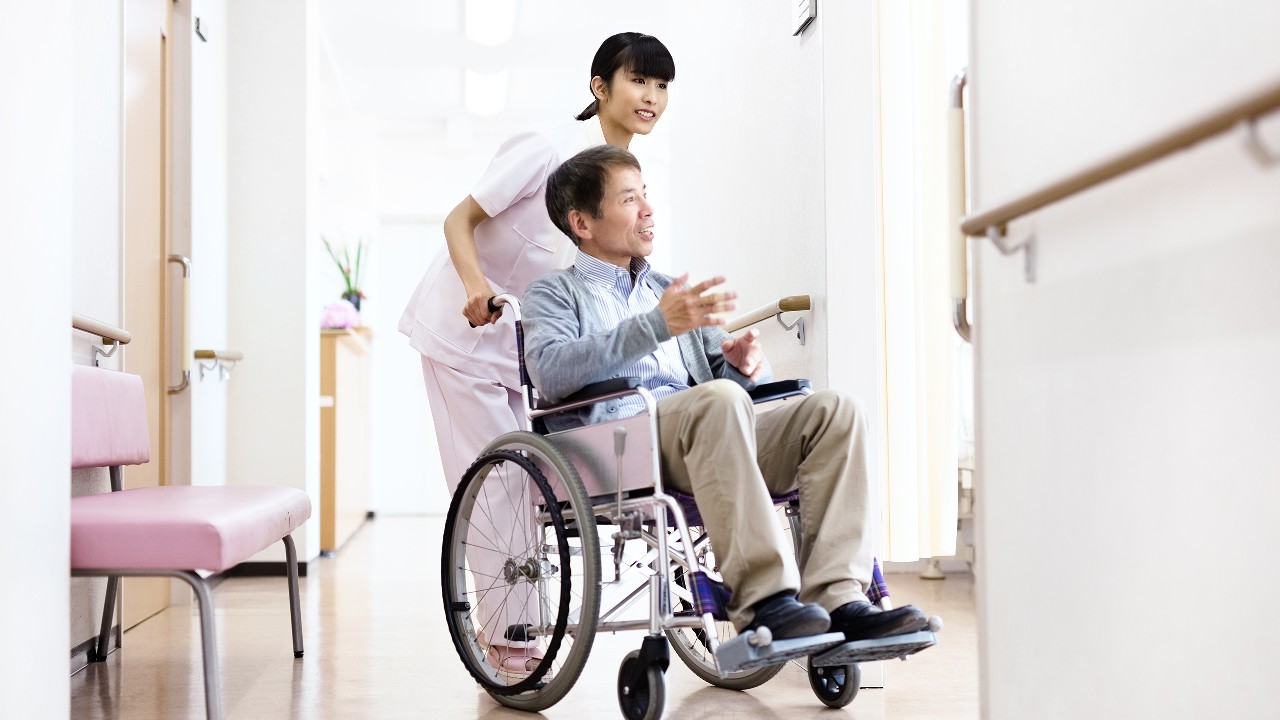 护士与坐在轮椅上的男士；图片使用于汇丰“意外万全保”页面。