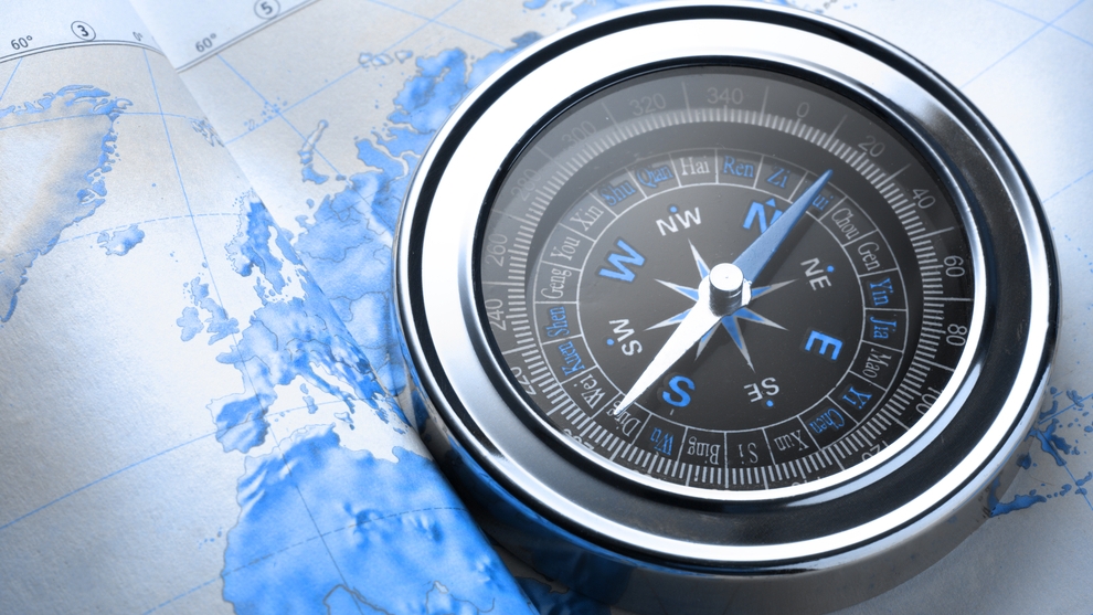 A compass is placed on a map; image used for FX viewpoint