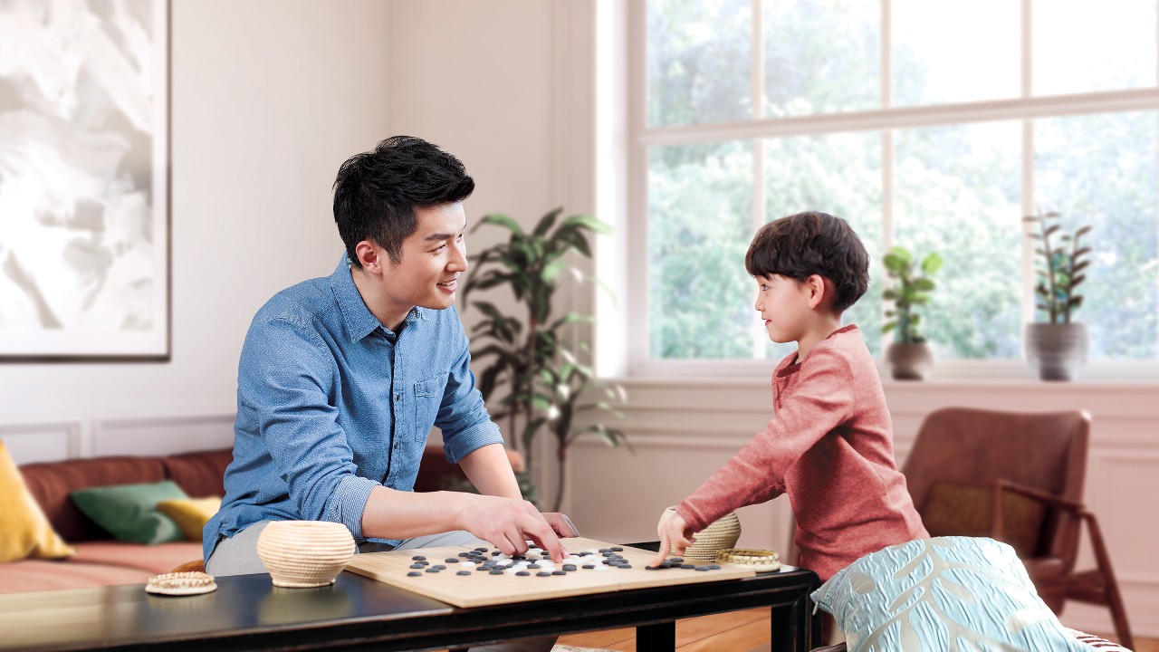 Father and son are playing Go; image used for Personal Instalment Loan Balance Consolidation Program.