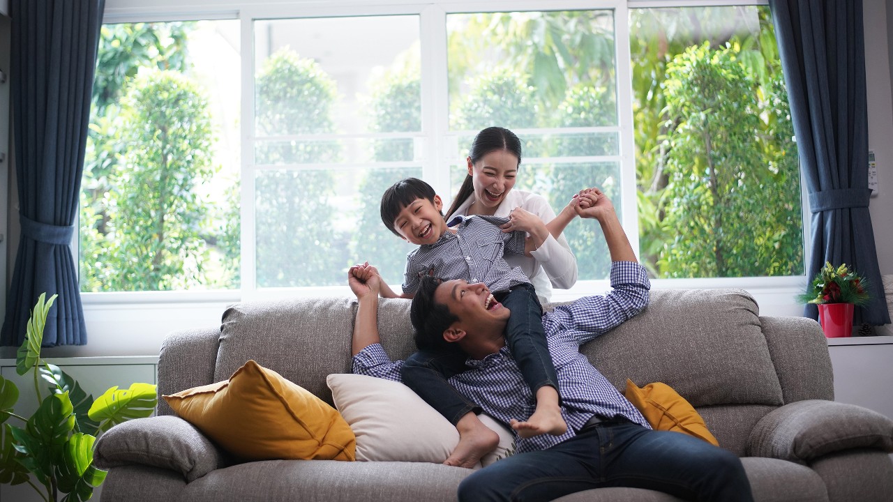 Family playing together and father giving his son piggyback ride; image used for HSBC ResidenceSurance.