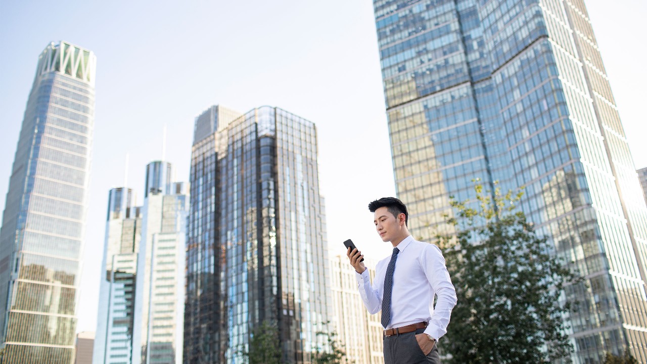A businessman is using his mobile on the street; image used for stocks page; image used for stock trading page