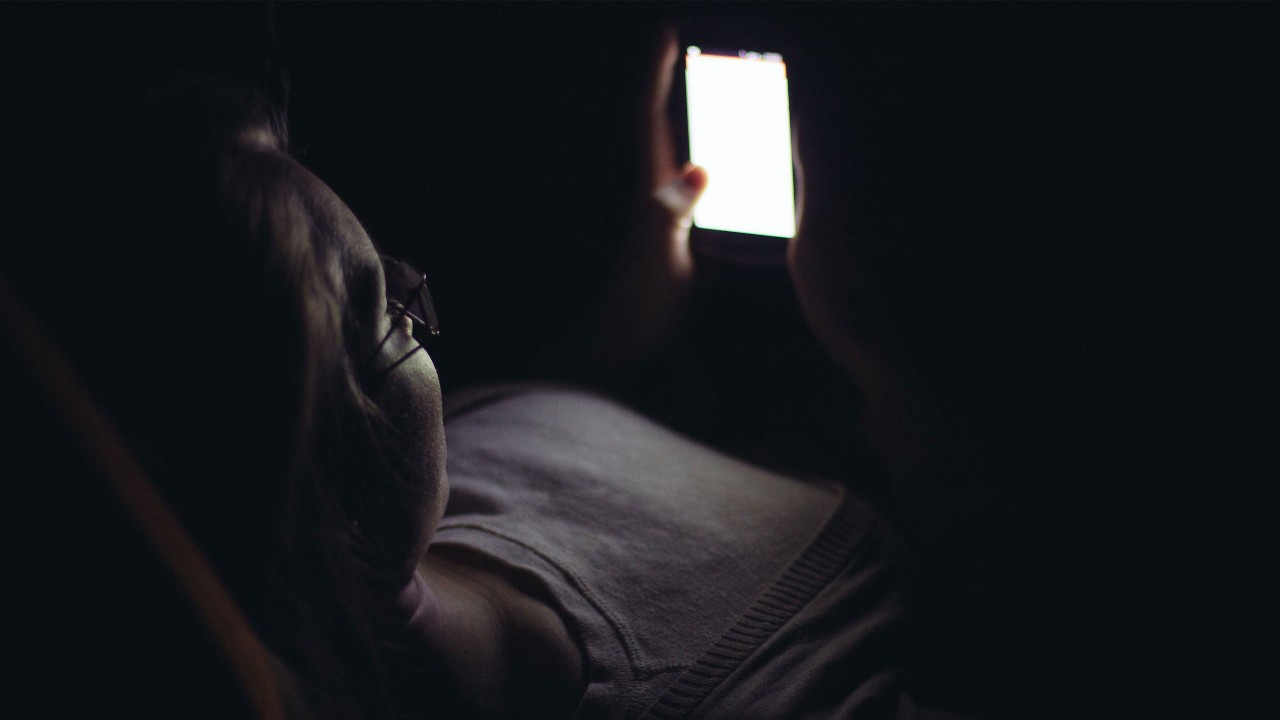 一個女人在夜晚使用她的智能手機；