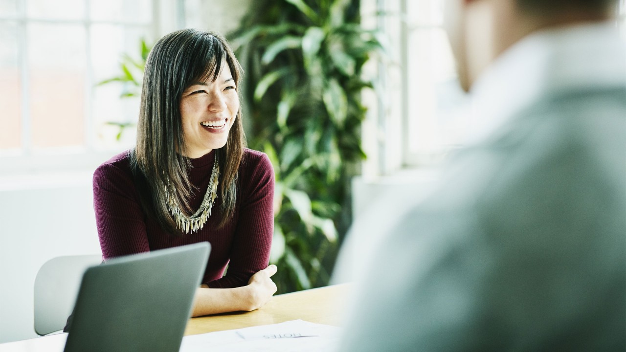 a smiling women in a meeting ; image used for HSBC Wealth Portfolio Plus